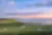 A tiny gentle stream from the ocean works its way onto a coastal plain on Ile d'Orleans with Quebec City vsible on the horizon