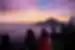 Leader with travellers enjoying the view of a purple sunrise during a Mount Batur hike in Bali, Indonesia