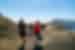 Intrepid leader and travellers hike the caldera ridge of Santorini with mountains visible beyond