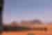 Square black tents with gold bands arrayed further from the camera in the desert of Wadi Rum in Jordan