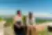 Intrepid travellers stop a hike on an ancient wall, enjoying Croatia's landscape with mountains beyond