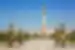 Ashgabat's white marble Independence monument towers over curated forests against a mountain backdrop