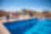 Group of Intrepid traveller children jumping into a pool with the kasbah of Ait Benhaddou in the background