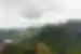 Large round stone spires seperate from a larger plateau covered in green trees rise up from a huge canyon
