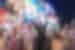 Intrepid travellers throw their hands up surrounded by screens and lights in Dotombori