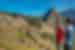 Guide points to ruins of Machu Picchu in the distance while talking to traveller in Peru
