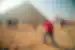 Leader takes a photo of a traveller posing in front of the Pyramids of Giza, Egypt
