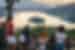 Group of travellers and leader look out over reflective Lake Bled from Ostrica mountain in Slovenia