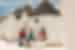 Travellers sitting on ledge outside traditional trulli buildings in Alberobello, Italy