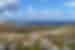 Intrepid traveller at the peak of a hike looking out over Delos and its ruins in the Cyclades
