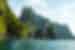 Longtail boat floats past huge limestone mountains in Khao Sok National Park in Thailand